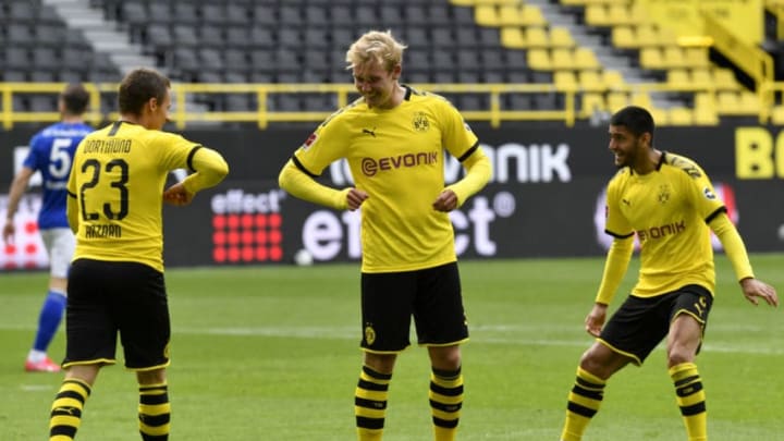 Dortmund's Belgian forward Thorgan Hazard celebrates with Dortmund's German forward Julian Brandt (C) after scoring his side's third goal during the German first division Bundesliga football match BVB Borussia Dortmund v Schalke 04 on May 16, 2020 in Dortmund, western Germany as the season resumed following a two-month absence due to the novel coronavirus COVID-19 pandemic. (Photo by Martin Meissner / POOL / AFP) / DFL REGULATIONS PROHIBIT ANY USE OF PHOTOGRAPHS AS IMAGE SEQUENCES AND/OR QUASI-VIDEO (Photo by MARTIN MEISSNER/POOL/AFP via Getty Images)