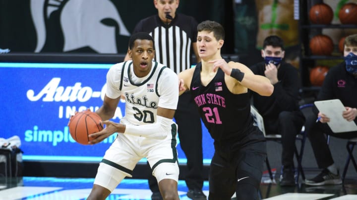 Feb 9, 2021; East Lansing, Michigan, USA; Michigan State Spartans forward Marcus Bingham Jr. (30) looks to pass the ball as Penn State Nittany Lions forward John Harrar (21) defends during the first half at Jack Breslin Student Events Center. Mandatory Credit: Tim Fuller-USA TODAY Sports