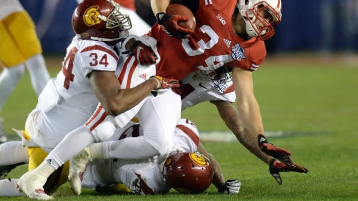 Dec 30, 2015; San Diego, CA, USA; Wisconsin Badgers fullback Derek Watt (34) is tackled by USC Trojans linebacker Olajuwon Tucker (34) during the first quarter in the 2015 Holiday Bowl at Qualcomm Stadium. Mandatory Credit: Jake Roth-USA TODAY Sports