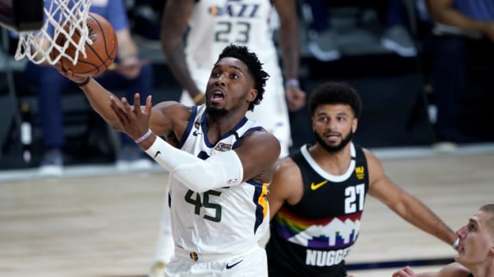 LAKE BUENA VISTA, FLORIDA - AUGUST 19: Donovan Mitchell #45 of the Utah Jazz drives to the basket as Jamal Murray #27 of the Denver Nuggets look on during the first half of Game Two of a first round playoff game at AdventHealth Arena at ESPN Wide World Of Sports Complex on August 19, 2020 in Lake Buena Vista, Florida. NOTE TO USER: User expressly acknowledges and agrees that, by downloading and or using this photograph, User is consenting to the terms and conditions of the Getty Images License Agreement. (Photo by Ashley Landis-Pool/Getty Images)