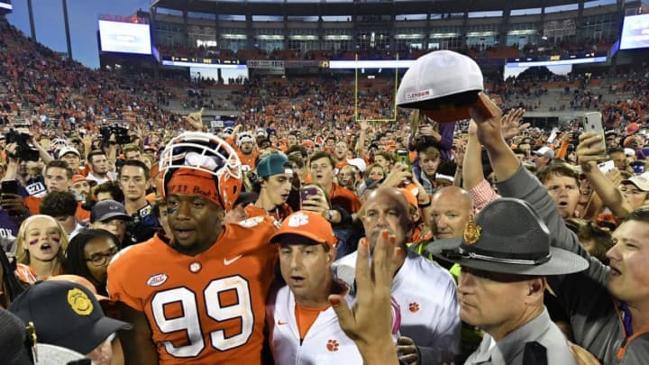 CLEMSON, SC - OCTOBER 20: Defensive end Clelin Ferrell #99 and head coach Dabo Swinney of the Clemson Tigers embrace at midfield while surrounded by fans singing the Clemson Alma Mater during the football game at Clemson Memorial Stadium on October 20, 2018 in Clemson, South Carolina. (Photo by Mike Comer/Getty Images)