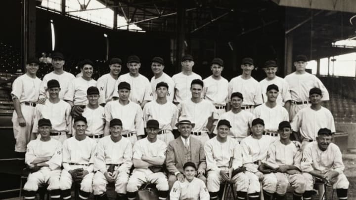 (Original Caption) This is the gang that will face the Giants in the World Series which starts off next week. Front row, left to right; Sam Rice, Walter Stewart, Leon Goslin, Al Schacht, President Clark Griffith, Manager Joe Cronin, Dave Harris, Cliff Bolton and Nick Altrock, Second Row left to right: Jack Russell, Al Thomas, Ed Chapman, Cecil Travis, Rog Burke, John Kerr, Monte Weaver and Buddy Myer. Third row, left to right: Luke Sewell, Moe Berg, Earl Whitehill- Ray Prim.- Fred Schulte Heinie Mansb, Alex McColl-0ssie Bluage- Jow Kuhel, Alvin Crowder and Bob Boken. Seated in front of Griffith is the mascot Mahorney. The World Series starts Oct. 3rd. (Photo by George Rinhart/Corbis via Getty Images)