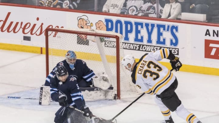 WINNIPEG, MB - MARCH 14: Dmitry Kulikov #5 of The Winnipeg Jets blocks the puck as Zdeno Chara #33 of the Boston Bruins looks for it during 1st period action on March 14, 2019 at Bell MTS Place in Winnipeg, Manitoba, Canada. (Photo by David Lipnowski/Getty Images)