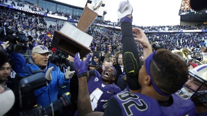 Nov 27, 2015; Seattle, WA, USA; Washington Huskies wide receiver Jaydon Mickens (4) lifts up the Apple Cup trophy while Washington governor Jay Inslee (left) claps after the Huskies defeated the Washington State Cougars 45-10 at Husky Stadium. Mandatory Credit: Jennifer Buchanan-USA TODAY Sports