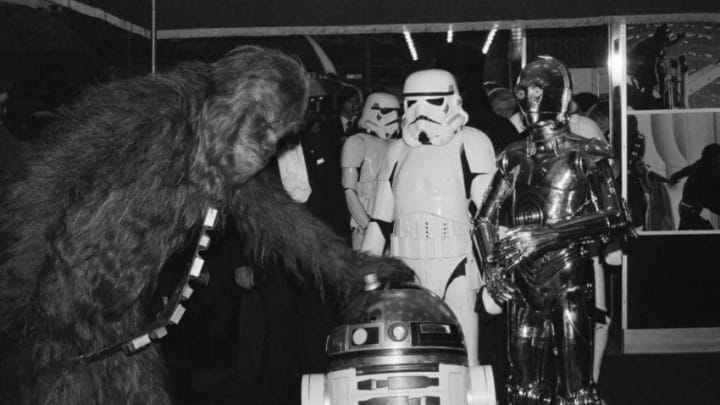 Actors dressed as fictional characters Chewbacca, R2-D2, C-3PO, and stormtroopers, who all appear in the Star Wars franchise, attend the royal premiere of 'The Empire Strikes Back' at the Odeon Leicester Square, London, UK, 20th May 1980. (Photo by Paul Thuaban/Keystone/Hulton Archive/Getty Images)
