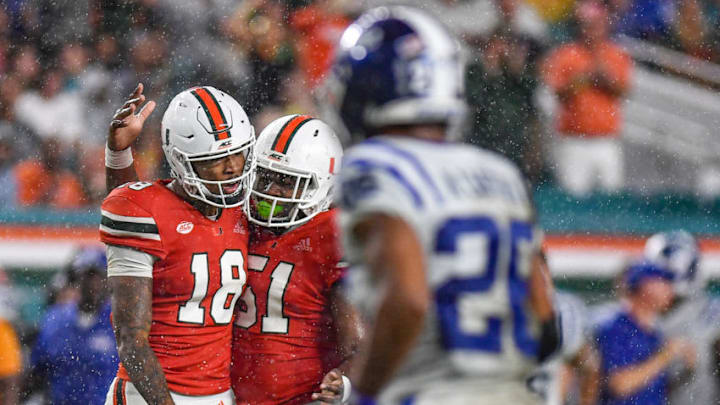 MIAMI, FL - NOVEMBER 03: Lawrence Cager #18 and DJ Scaife Jr. #51 of the Miami Hurricanes celerbrate a catch in the rain in the first half against the Duke Blue Devils at Hard Rock Stadium on November 3, 2018 in Miami, Florida. (Photo by Mark Brown/Getty Images)