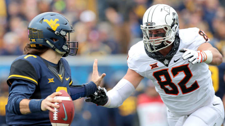 MORGANTOWN, WV - OCTOBER 28: West Virginia Mountaineers quarterback Will Grier (7) is pressured and sacked by Oklahoma State Cowboys defensive end Cole Walterscheid (82) during the first quarter of the college football game between the Oklahoma State Cowboys and the West Virginia Mountaineers on October 28, 2017, at Mountaineer Field at Milan Puskar Stadium in Morgantown, WV. Oklahoma State defeated West Virginia 50-39. (Photo by Frank Jansky/Icon Sportswire via Getty Images)