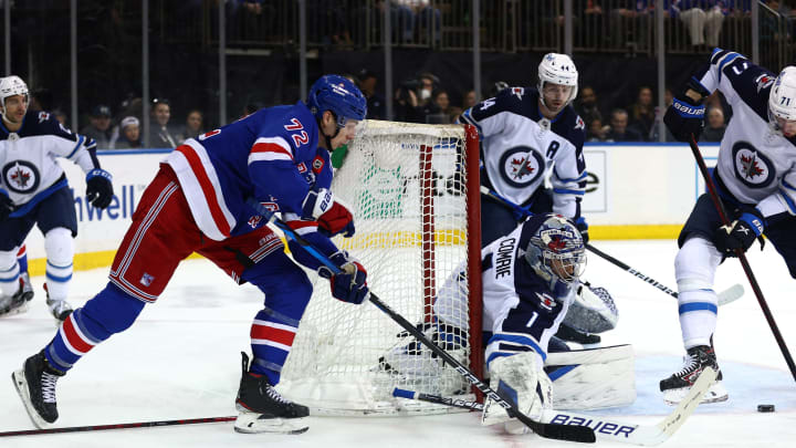 NEW YORK, NEW YORK – APRIL 19: Filip Chytil #72 of the New York Rangers wraps around the net as Eric Comrie #1 of the Winnipeg Jets makes the save during the second period at Madison Square Garden on April 19, 2022 in New York City. (Photo by Elsa/Getty Images)