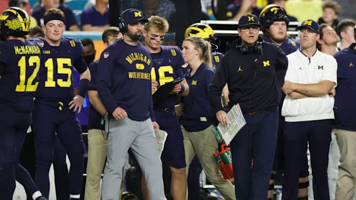 Dec 31, 2021; Miami Gardens, Florida, USA; Michigan Wolverines head coach Jim Harbaugh (front, right) watches from the sideline in the third quarter against the Georgia Bulldogs during the Orange Bowl college football CFP national semifinal game at Hard Rock Stadium. Mandatory Credit: Sam Navarro-USA TODAY Sports