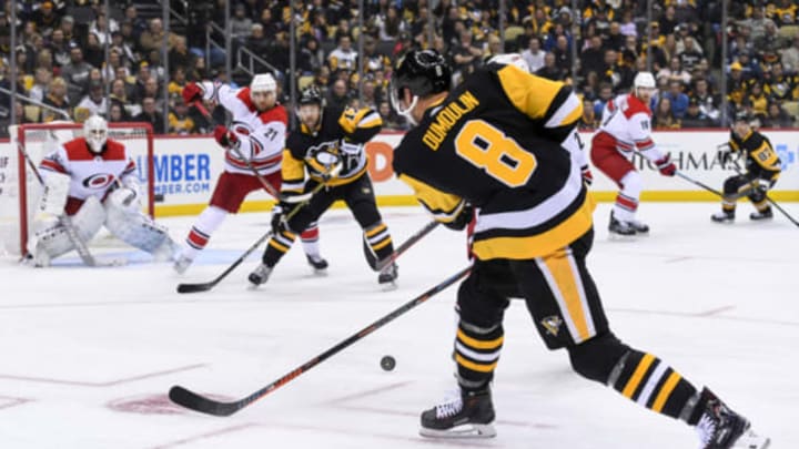 PITTSBURGH, PA – MARCH 31: Pittsburgh Penguins Defenseman Brian Dumoulin (8) passes the puck as Pittsburgh Penguins Right Wing Bryan Rust (17) and Carolina Hurricanes Left Wing Nino Niederreiter (21) battle in front of Carolina Hurricanes Goalie Curtis McElhinney (35) during the second period in the NHL game between the Pittsburgh Penguins and the Carolina Hurricanes on March 31, 2019, at PPG Paints Arena in Pittsburgh, PA. (Photo by Jeanine Leech/Icon Sportswire via Getty Images)