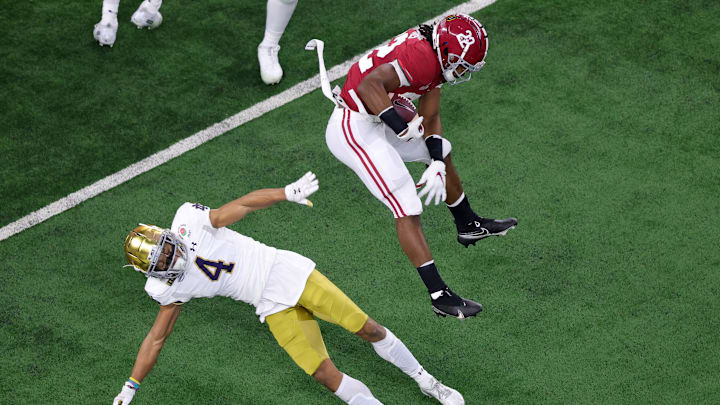 ARLINGTON, TEXAS – JANUARY 01: Running back Najee Harris #22 of the Alabama Crimson Tide leaps cornerback Nick McCloud #4 of the Notre Dame Fighting Irish during the first quarter of the 2021 College Football Playoff Semifinal Game at the Rose Bowl Game presented by Capital One at AT&T Stadium on January 01, 2021 in Arlington, Texas. (Photo by Carmen Mandato/Getty Images)