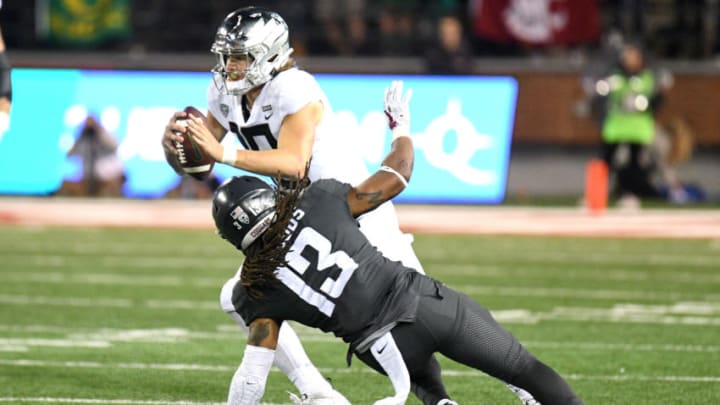 PULLMAN, WA – OCTOBER 20: PULLMAN, WA – SEPTEMBER 08: Oregon quarterback Justin Herbert (10) eludes the tackle of WSU linebacker Jahad Woods (13) during the game between the Washington State Cougars and the Oregon Ducks played on October 20, 2018 in Pullman, Washington at Martin Stadium. (Photo by Robert Johnson/Icon Sportswire via Getty Images)