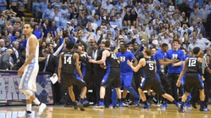 Feb 17, 2016; Chapel Hill, NC, USA; Duke Blue Devils players celebrate as North Carolina Tar Heels guard Marcus Paige (5) walks off the court after the game. The Duke Blue Devils defeated the North Carolina Tar Heels 74-73 at Dean E. Smith Center. Mandatory Credit: Bob Donnan-USA TODAY Sports