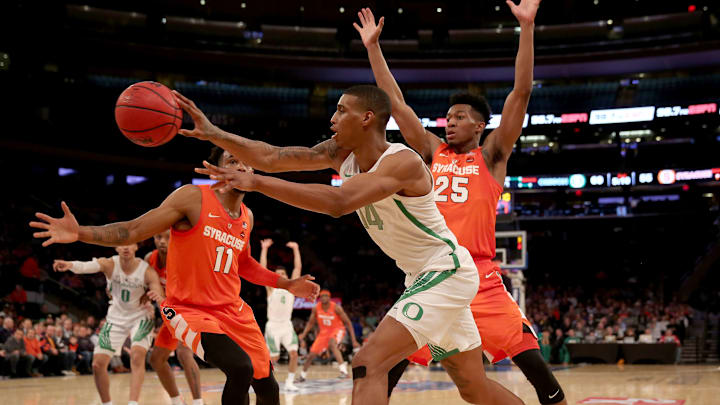 NEW YORK, NEW YORK – NOVEMBER 16: Kenny Wooten #14 of the Oregon Ducks passes the ball under pressure from Oshae Brissett #11 and Tyus Battle #25 of the Syracuse Orange during the 2K Empire Classic at Madison Square Garden on November 16, 2018 in New York City.The Oregon Ducks defeated the Syracuse Orange 80-65. (Photo by Elsa/Getty Images)