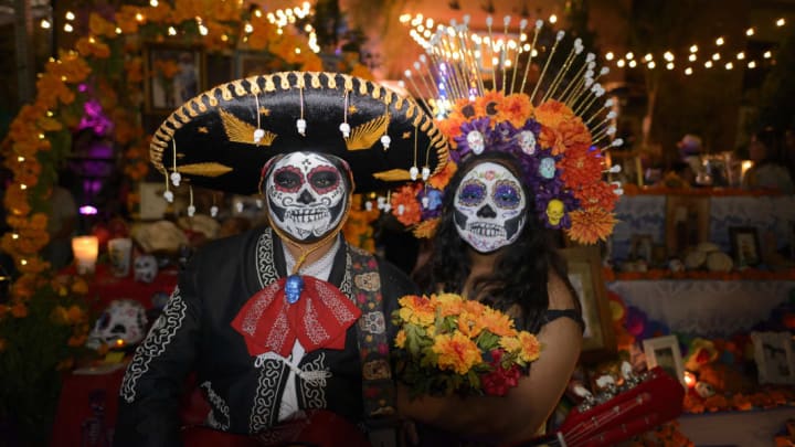 Participants standing in front of an altar during Día de los Muertos