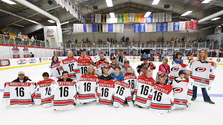 MARQUETTE, MI – OCTOBER 4 : Fans pose on the ice with there team signed Carolina Hurricanes Kraft Hockeyville jerseys after the NHL pre-season game at Lakeview Arena on October 4, 2016 in Marquette, Michigan. (Photo by Brian Babineau/NHLI via Getty Images)