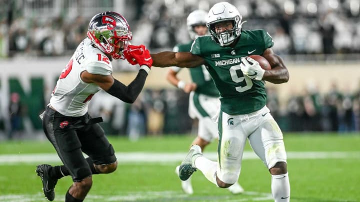 Michigan State’s Kenneth Walker III, right, stiff arms Western Kentucky’s Kahlef Hailassie on a run during the second quarter on Saturday, Oct. 2, 2021, at Spartan Stadium in East Lansing.211002 Msu Wku Fb 144a