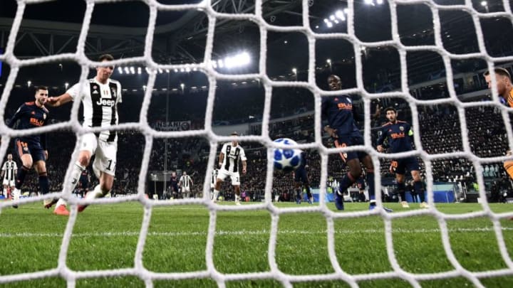 Juventus' Croatian forward Mario Mandzukic (L) shoots to open the scoring past Valencia's Brazilian goalkeeper Neto (R) during the UEFA Champions League group H football match Juventus vs Valence on November 27, 2018 at the Juventus stadium in Turin. (Photo by Marco BERTORELLO / AFP) (Photo credit should read MARCO BERTORELLO/AFP/Getty Images)