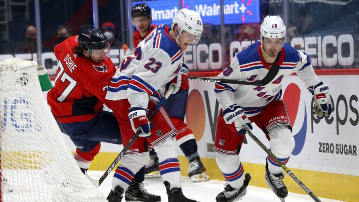 T.J. Oshie #77 of the Washington Capitals goes after the puck against Adam Fox #23 and Chris Kreider #20 of the New York Rangers (Photo by Rob Carr/Getty Images)