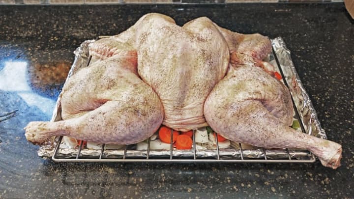 A spatchcocked turkey on a roasting rack.