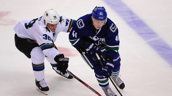 Sep 23, 2014; Vancouver, British Columbia, CAN; Vancouver Canucks left wing Ronalds Kenins (41) takes possession of the puck against San Jose Sharks center Micheal Haley (38) during the third period at Rogers Arena. The Vancouver Canucks won 4-2. Mandatory Credit: Anne-Marie Sorvin-USA TODAY Sport