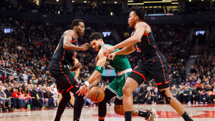 TORONTO, ON - DECEMBER 05: Jayson Tatum #0 of the Boston Celtics is stopped as he dribbles through Christian Koloko #35 and Scottie Barnes #4 of the Toronto Raptors (Photo by Cole Burston/Getty Images)