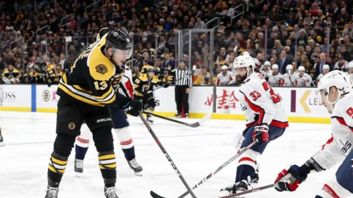 BOSTON, MA - NOVEMBER 16: Boston Bruins center Charlie Coyle (13) slides a pass between Washington Capitals defenseman Radko Gudas (33) and Washington Capitals defenseman Dmitry Orlov (9) during a game between the Boston Bruins and the Washington Capitals on November 16, 2019, at TD Garden in Boston, Massachusetts. (Photo by Fred Kfoury III/Icon Sportswire via Getty Images)