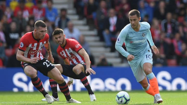 SOUTHAMPTON, ENGLAND – OCTOBER 07: Eden Hazard of Chelsea runs with the ball under pressure from Pierre-Emile Hojbjerg and Wesley Hoedt of Southampton during the Premier League match between Southampton FC and Chelsea FC at St Mary’s Stadium on October 7, 2018 in Southampton, United Kingdom. (Photo by Mike Hewitt/Getty Images)