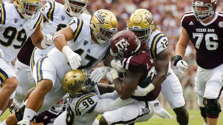 Sep 3, 2016; College Station, TX, USA; Texas A&M Aggies running back James White (20) is tackled by defensive lineman Eddie Vanderdoes (47) and defensive lineman Takkarist McKinley (98) and linebacker Jayon Brown (12) during a game at Kyle Field. Texas A&M won in overtime 31-24. Mandatory Credit: Ray Carlin-USA TODAY Sports