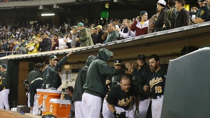 June 12, 2013; Oakland, CA, USA; Oakland Athletics first baseman Brandon Moss (37) celebrates in the dugout with teammates after hitting a home run against the New York Yankees during the eighth inning at O.co Coliseum. The Oakland Athletics defeated the New York Yankees 5-2. Mandatory Credit: Kelley L Cox-USA TODAY Sports