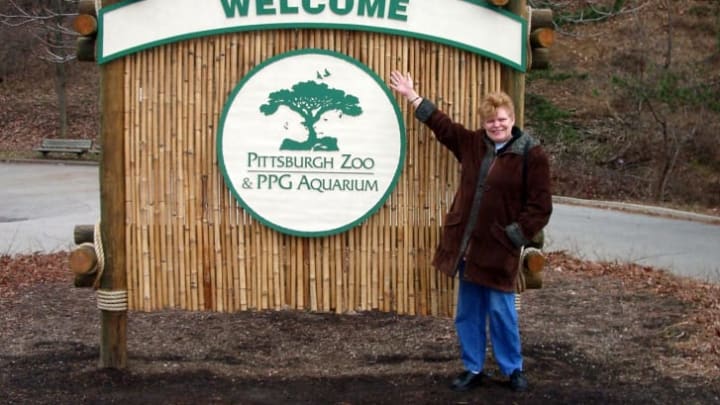 A visitor poses beside the sign in 2006.