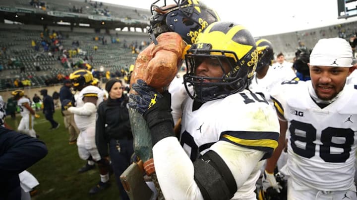 EAST LANSING, MI - OCTOBER 20: Devin Bush #10 of the Michigan Wolverines carries the Paul Bunyan trophy off the field after beating the Michigan State Spartans 21-7 at Spartan Stadium on October 20, 2018 in East Lansing, Michigan. (Photo by Gregory Shamus/Getty Images)