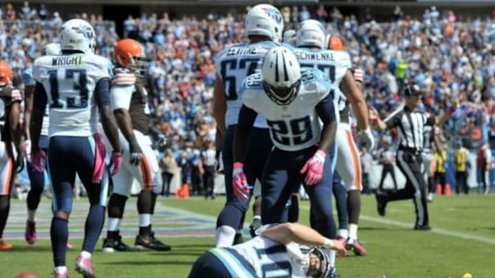 Oct 5, 2014; Nashville, TN, USA; Tennessee Titans running back Leon Washington (29) checks on quarterback Jake Locker (10) who rolls on the ground after scoring a touchdown and being hit by Cleveland Browns inside linebacker Chris Kirksey (not pictured) during the first half at LP Field. Mandatory Credit: Jim Brown-USA TODAY Sports