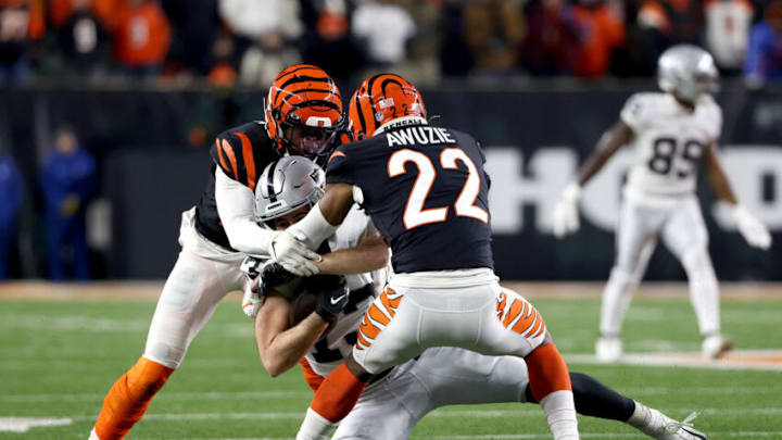 CINCINNATI, OHIO - JANUARY 15: Eli Apple #20 and Chidobe Awuzie #22 of the Cincinnati Bengals tackle Hunter Renfrow #13 of the Las Vegas Raiders during the second half of the AFC Wild Card playoff game at Paul Brown Stadium on January 15, 2022 in Cincinnati, Ohio. (Photo by Dylan Buell/Getty Images) CINCINNATI, OHIO - JANUARY 15: Eli Apple #20 and Chidobe Awuzie #22 of the Cincinnati Bengals tackle Hunter Renfrow #13 of the Las Vegas Raiders during the second half of the AFC Wild Card playoff game at Paul Brown Stadium on January 15, 2022 in Cincinnati, Ohio. (Photo by Dylan Buell/Getty Images)