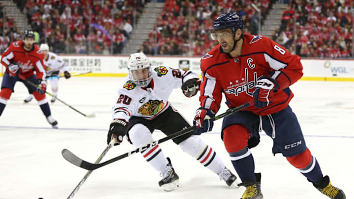 WASHINGTON, DC - NOVEMBER 21: Alex Ovechkin #8 of the Washington Capitals skates with the puck in front of Brandon Saad #20 of the Chicago Blackhawks during the second period at Capital One Arena on November 21, 2018 in Washington, DC. (Photo by Will Newton/Getty Images)