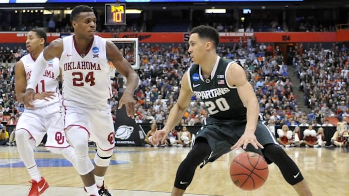 Mar 27, 2015; Syracuse, NY, USA; Michigan State Spartans guard Travis Trice (20) handles the ball against Oklahoma Sooners guard Buddy Hield (24) during the second half in the semifinals of the east regional of the 2015 NCAA Tournament at Carrier Dome. Mandatory Credit: Mark Konezny-USA TODAY Sports
