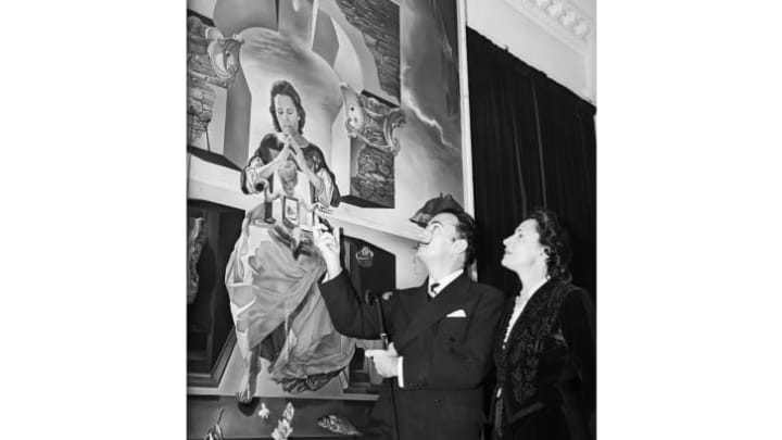 Dalí and Gala look up at his painting The Madonna of Port Llegat, which the artist painted using Gala as the model for the Madonna.