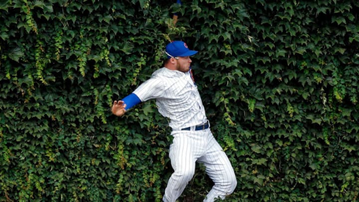 CHICAGO, IL - AUGUST 15: Ian Happ #8 of the Chicago Cubs makes a leaping catch for an out against the Milwaukee Brewers and collides with the outfield wall during the ninth inning at Wrigley Field on August 15, 2018 in Chicago, Illinois. The Chicago Cubs won 8-4. (Photo by Jon Durr/Getty Images)