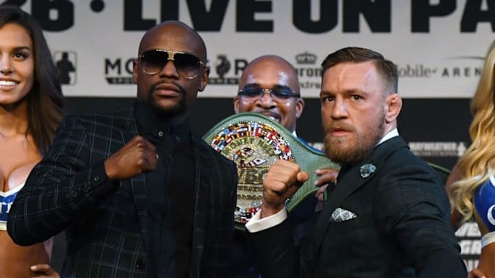 LAS VEGAS, NV - AUGUST 23: Boxer Floyd Mayweather Jr. (L) and UFC lightweight champion Conor McGregor (R) pose as Mayweather Promotions CEO Leonard Ellerbe (C) looks on during a news conference at the KA Theatre at MGM Grand Hotel