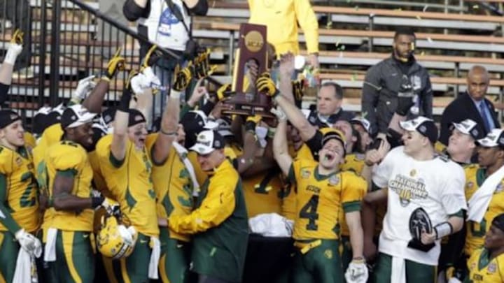 Jan 4, 2014; Frisco, TX, USA; Members of the North Dakota State Bison team and head coach Craig Bohl hold up the championship trophy after the division 1 championship game against the Towson Tigers at Toyota Stadium. North Dakota State beat Towson 35-7. Mandatory Credit: Tim Heitman-USA TODAY Sports