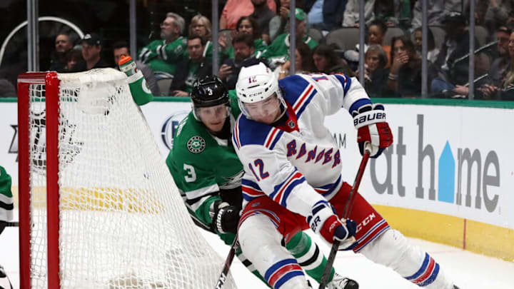 DALLAS, TEXAS - MARCH 10: Julien Gauthier #12 of the New York Rangers skates the puck against John Klingberg #3 of the Dallas Stars during the second period at American Airlines Center on March 10, 2020 in Dallas, Texas. (Photo by Ronald Martinez/Getty Images)