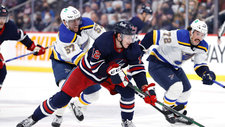 Nov 9, 2021; Winnipeg, Manitoba, CAN; St. Louis Blues left wing David Perron (57) stick checks Winnipeg Jets center Jansen Harkins (12) in the second period at Canada Life Centre. Mandatory Credit: James Carey Lauder-USA TODAY Sports