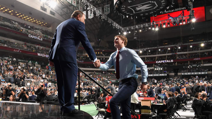 DALLAS, TX – JUNE 22: Alexander Alexeyev greets NHL commissioner Gary Bettman after being selected thirty-first overall by the Washington Capitals during the first round of the 2018 NHL Draft at American Airlines Center on June 22, 2018 in Dallas, Texas. (Photo by Brian Babineau/NHLI via Getty Images)