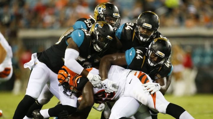 Aug 28, 2016; Jacksonville, FL, USA; Cincinnati Bengals running back Tra Carson (39) is tackled by Jacksonville Jaguars linebacker Sean Porter (53) along with linebacker Myles Jack (44) and nose tackle Richard Ash (94) and defensive tackle Tyson Alualu (93) in the third quarter at EverBank Field. The Jacksonville Jaguars won 26-21. Mandatory Credit: Logan Bowles-USA TODAY Sports