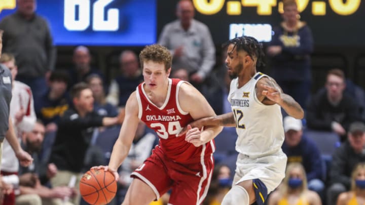 Jan 26, 2022; Morgantown, West Virginia, USA; Oklahoma Sooners forward Jacob Groves (34) dribbles with pressure from West Virginia Mountaineers guard Taz Sherman (12) during the second half at WVU Coliseum. Mandatory Credit: Ben Queen-USA TODAY Sports