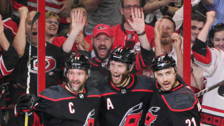 RALEIGH, NC - MAY 03: Carolina Hurricanes center Jordan Staal (11) and Carolina Hurricanes right wing Nino Niederreiter (21) congratulate Carolina Hurricanes right wing Justin Williams (14) after scoring his 100th playoff point during a game between the Carolina Hurricanes and the New York Islanders on March 3, 2019 at the PNC Arena in Raleigh, NC. (Photo by Greg Thompson/Icon Sportswire via Getty Images)