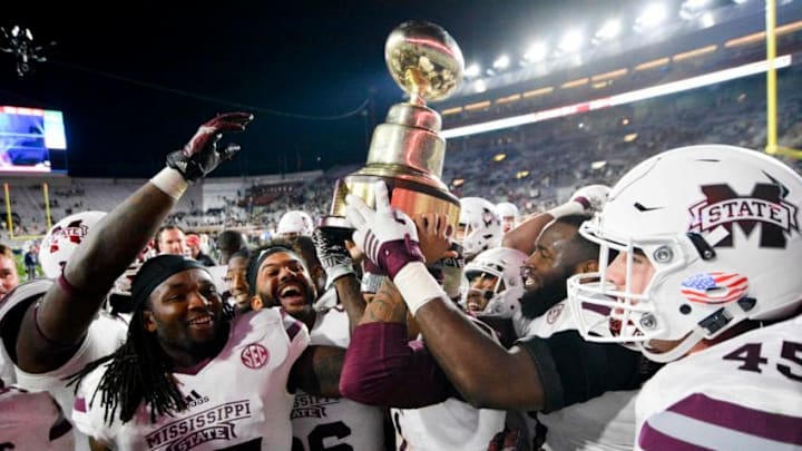 Nov 26, 2016; Oxford, MS, USA; Mississippi State Bulldogs players celebrate with the Egg Bowl trophy after the game against the Mississippi Rebels at Vaught-Hemingway Stadium. Mississippi State won 55-20 Mandatory Credit: Matt Bush-USA TODAY Sports