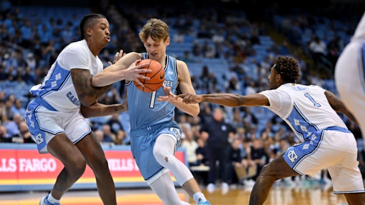 CHAPEL HILL, NORTH CAROLINA - DECEMBER 13: Stephen Clark #1 of the Citadel Bulldogs drives between Armando Bacot #5 and Leaky Black #1 of the North Carolina Tar Heels during the first half of their game at the Dean E. Smith Center on December 13, 2022 in Chapel Hill, North Carolina. The Tar Heels won 100-64. (Photo by Grant Halverson/Getty Images)