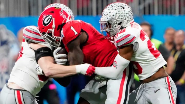 Dec 31, 2022; Atlanta, Georgia, USA; Ohio State Buckeyes linebacker Tommy Eichenberg (35) and cornerback Cameron Brown (26) come together to tackle Georgia Bulldogs wide receiver Marcus Rosemy-Jacksaint (1) after a catch during the first quarter of the Peach Bowl in the College Football Playoff semifinal at Mercedes-Benz Stadium.Osu22uga Kwr 14