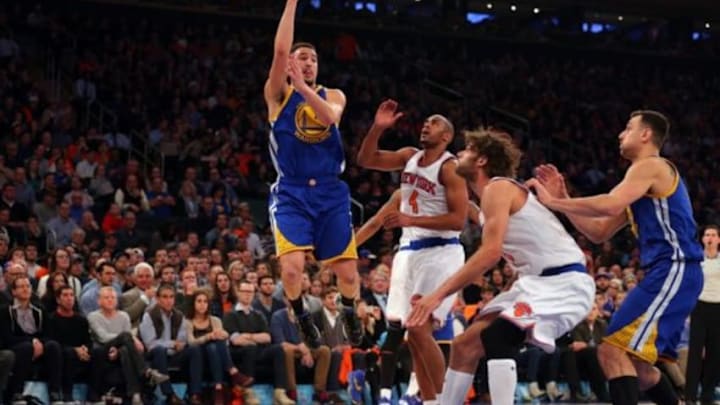Jan 31, 2016; New York, NY, USA; Golden State Warriors shooting guard Klay Thompson (11) passes the ball against New York Knicks shooting guard Arron Afflalo (4) and Knicks center Robin Lopez (8) during the first quarter at Madison Square Garden. Mandatory Credit: Brad Penner-USA TODAY Sports
